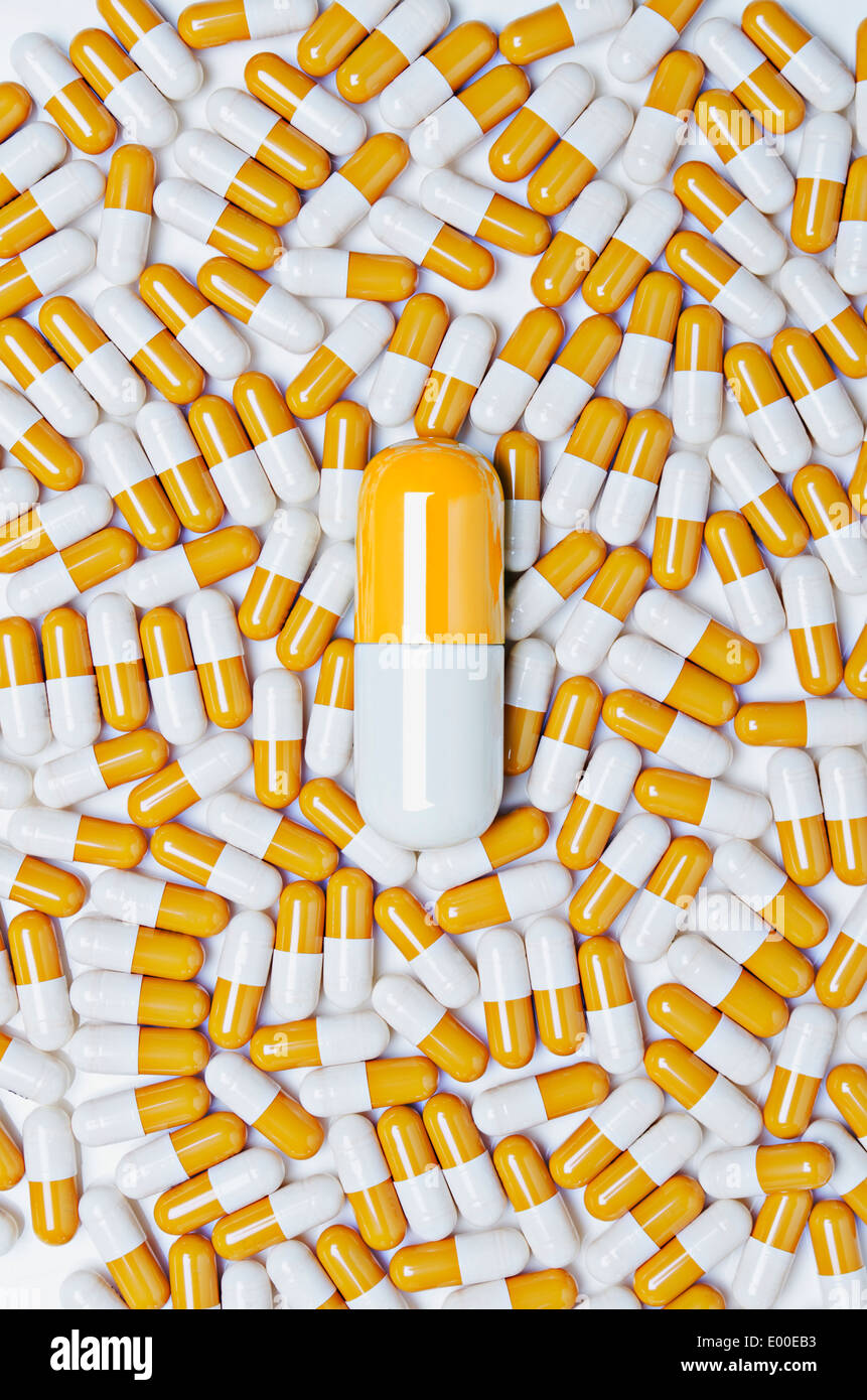 Large pill surrounded by small pills Stock Photo