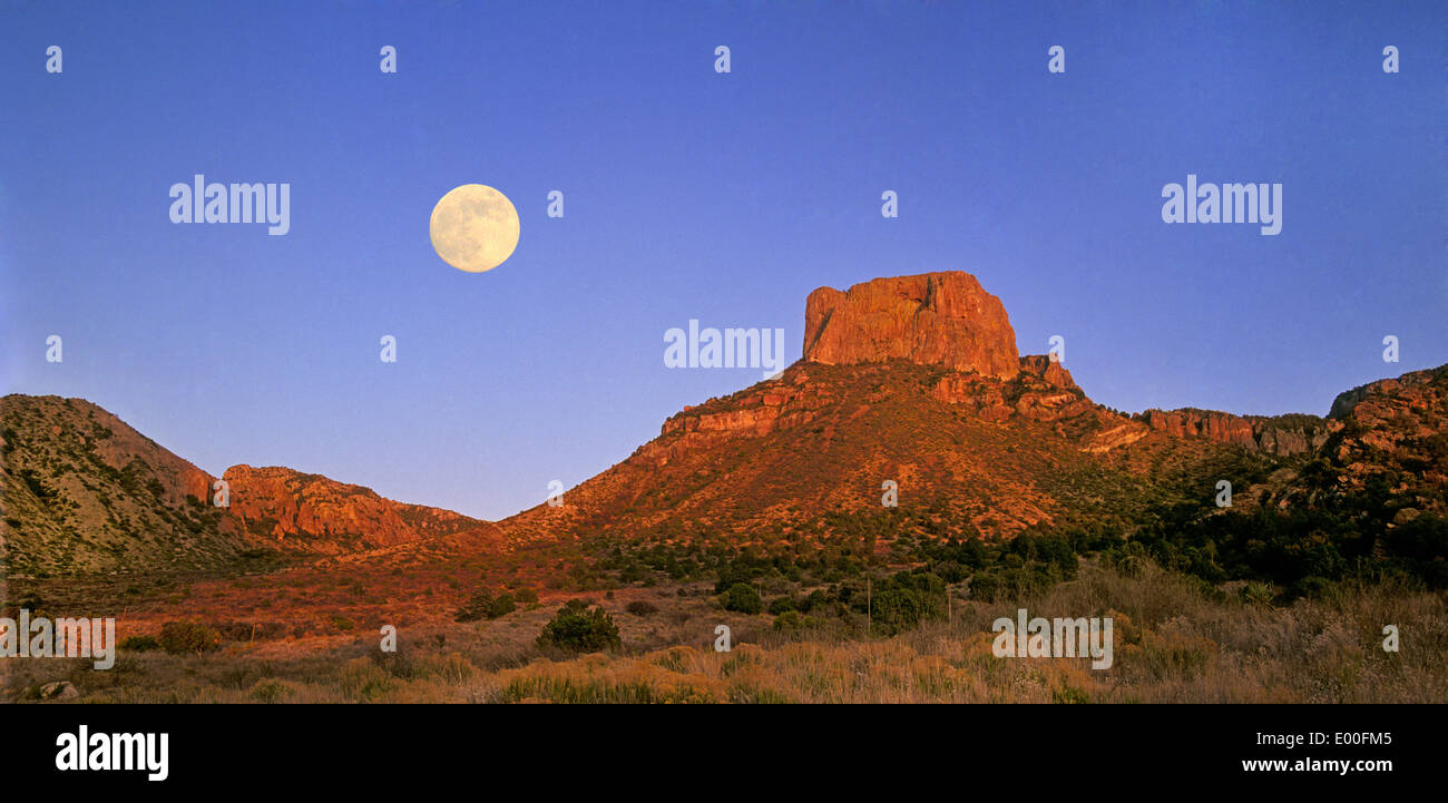 A full moon rises over the Chisos Mountains in Big Bend National Park, Texas Stock Photo