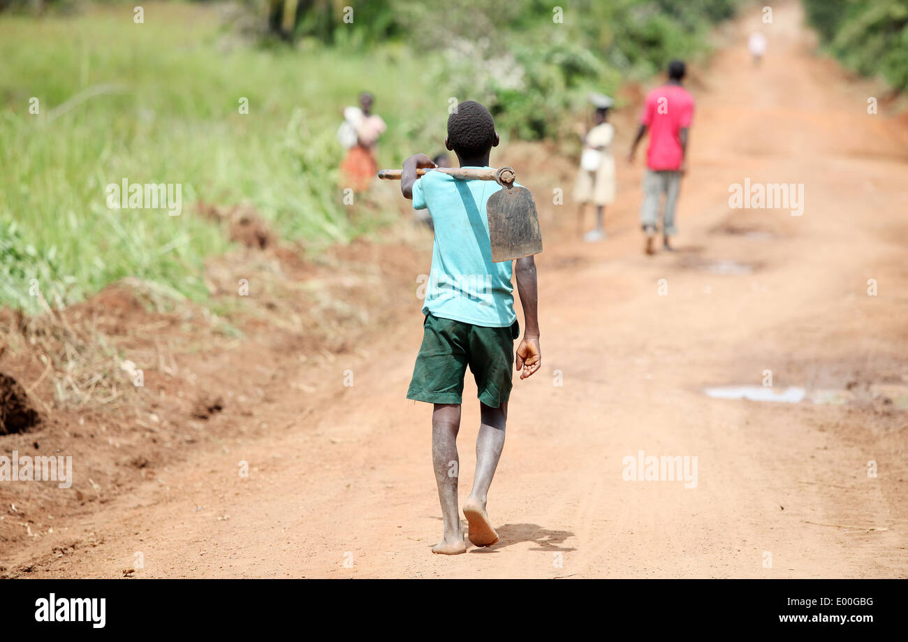 A young boy heads out to farm the land in the Lira district of northern Uganda Stock Photo