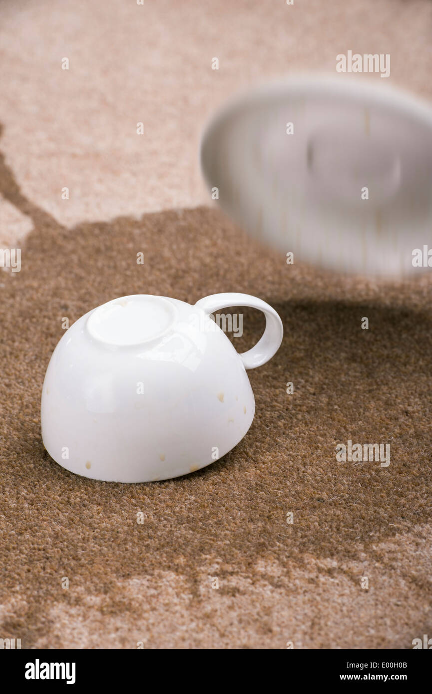 Cup of coffee dropped onto a carpet. Stock Photo