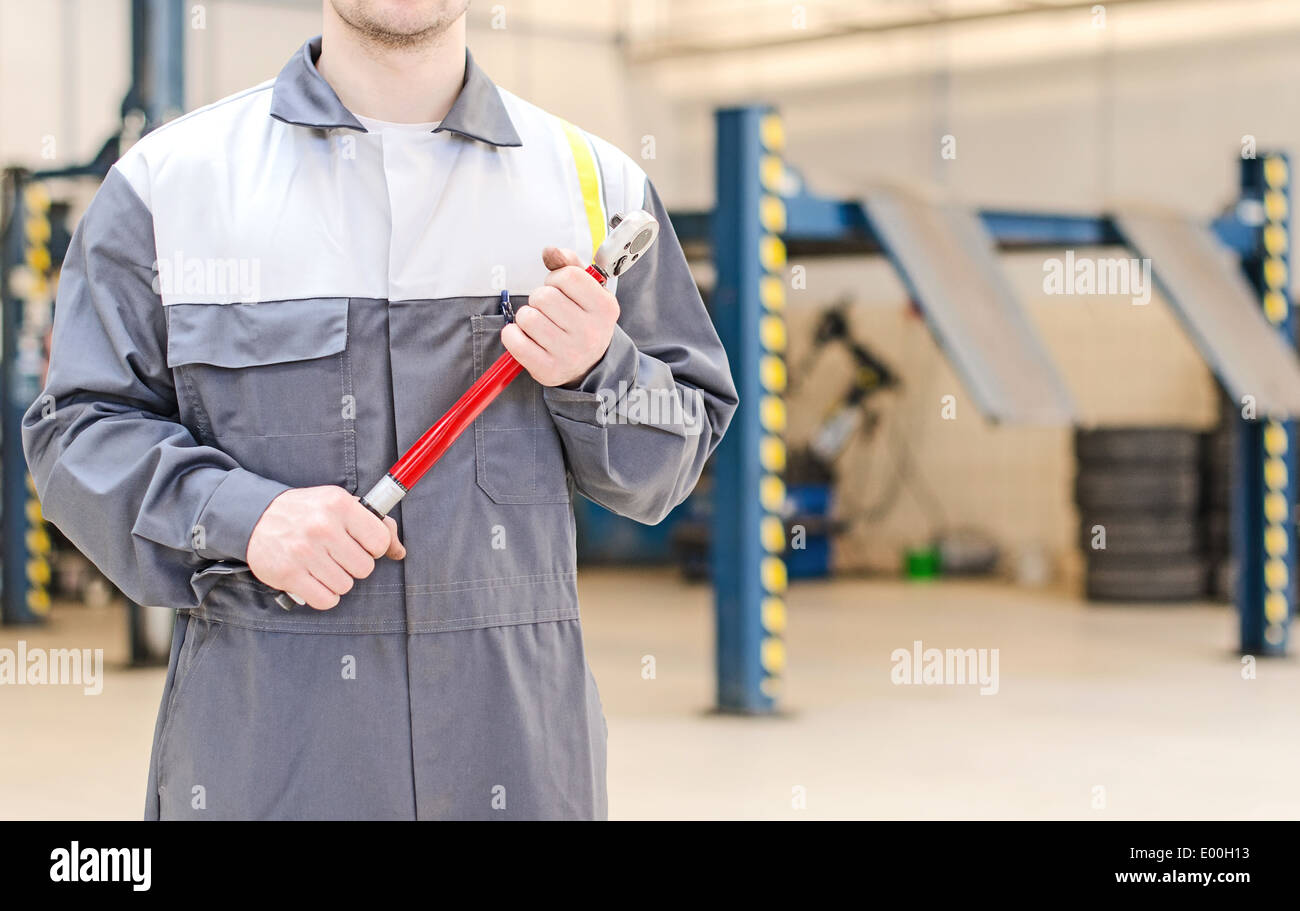 Mechanic with torque wrench at auto repair shop. Stock Photo