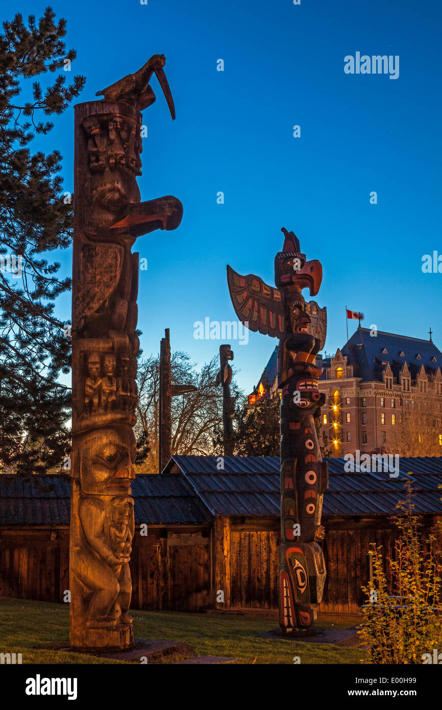 First Nations aboriginal totem poles in Thunderbird Park at sunset-Victoria, British Columbia, Canada. Stock Photo