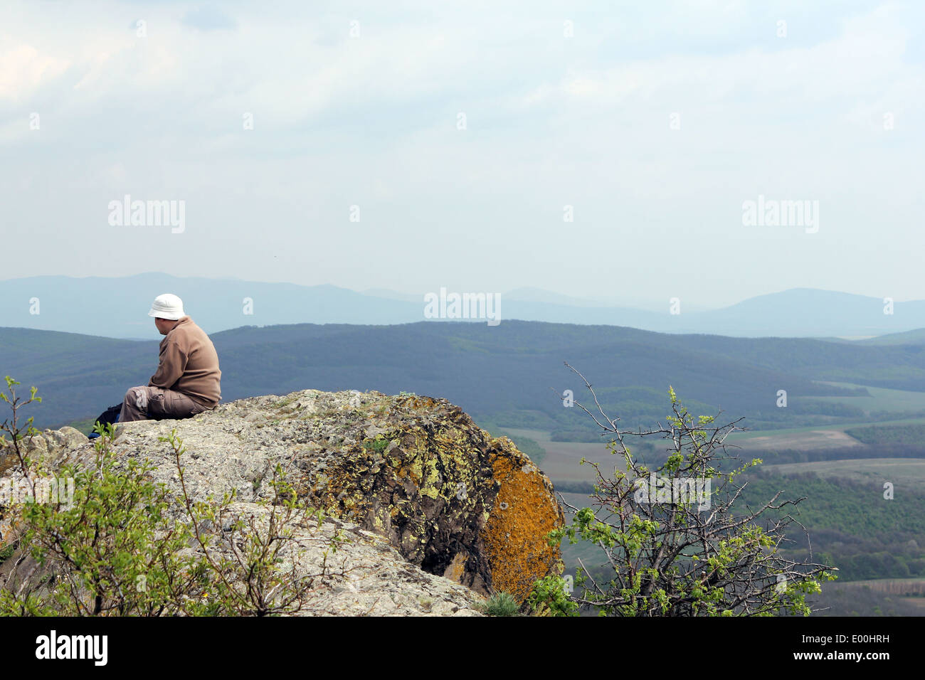 lonely man sitting on top of the mountain Stock Photo - Alamy