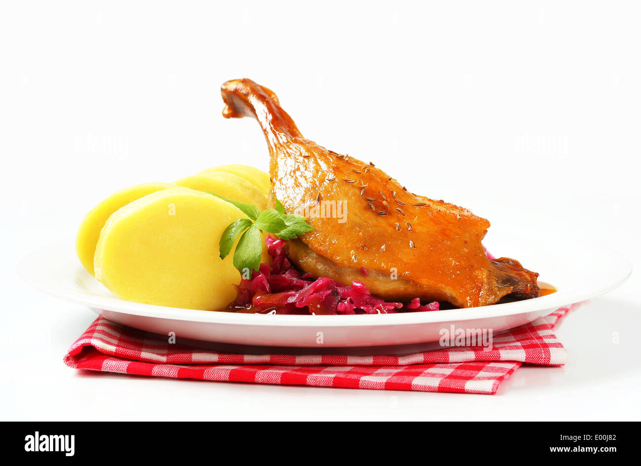 Dish of roast duck leg with potato dumplings and braised red cabbage