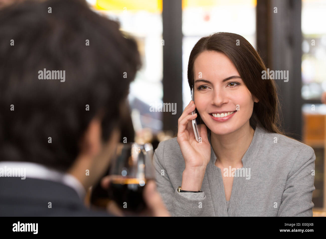 Female Male cheerful smartphone dinner bar Stock Photo