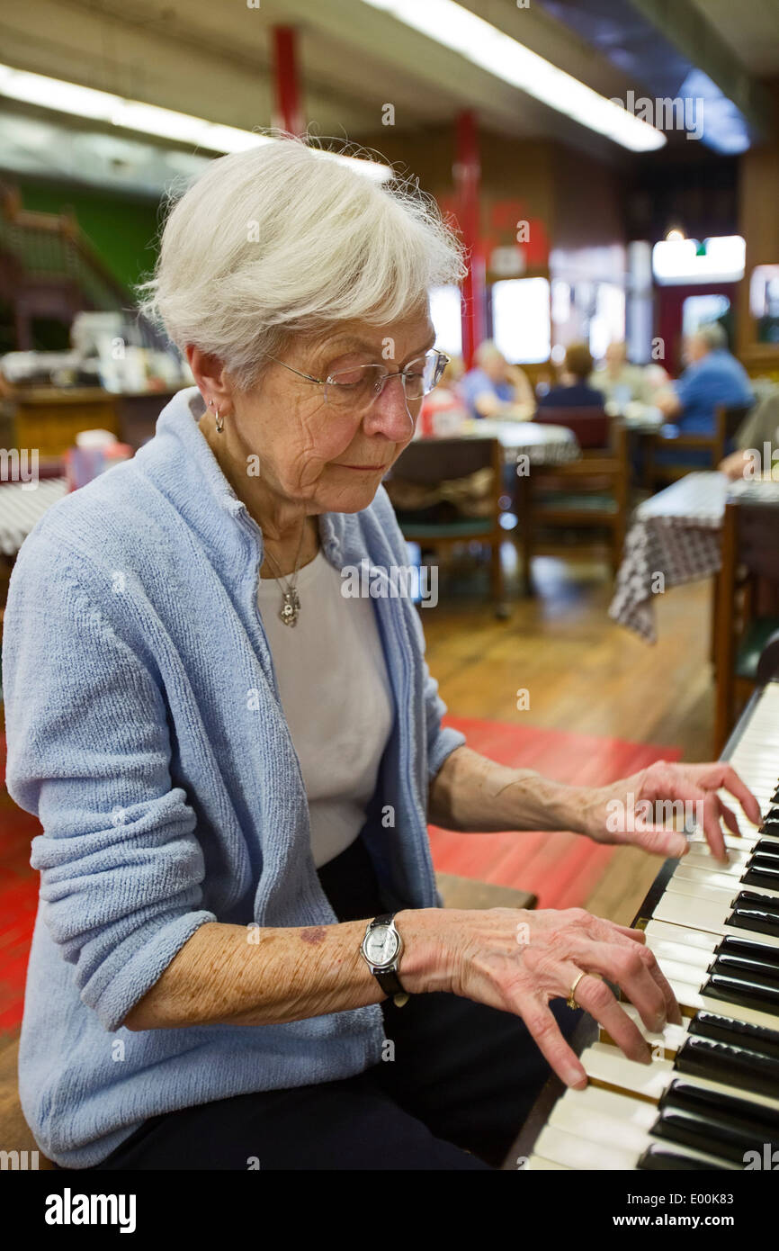 83-Year-Old Woman Plays Piano in Pizza Restaurant Stock Photo