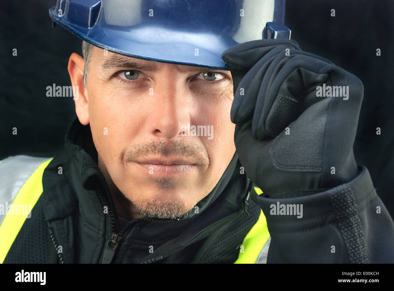 Close-up of a construction worker putting on his hardhat. Stock Photo