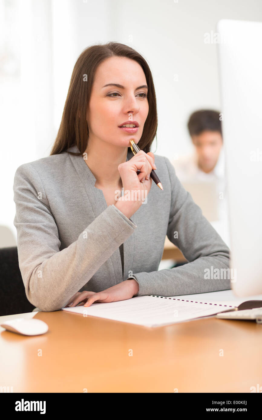 Pretty woman desk computer background colleague Stock Photo