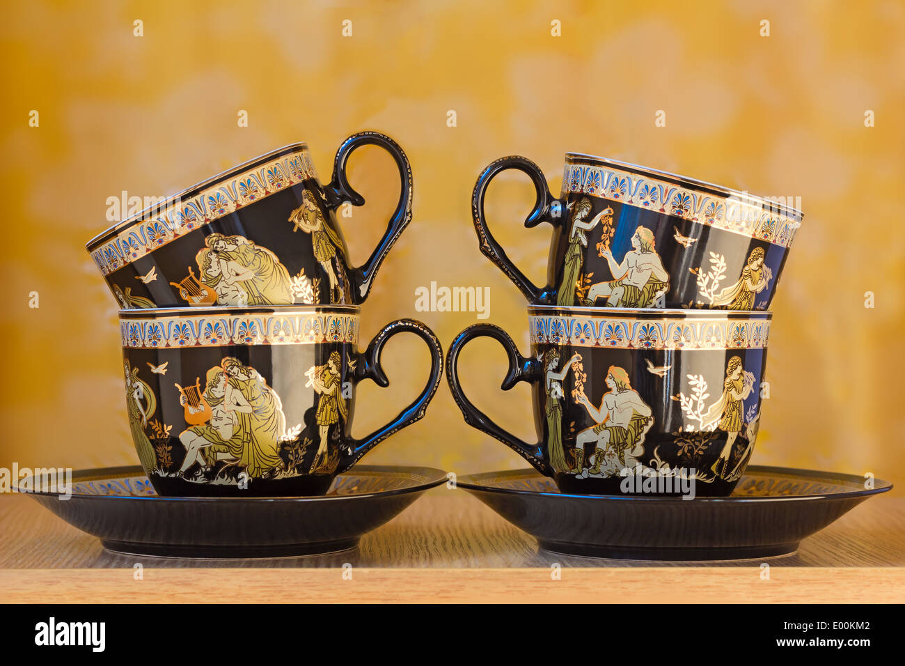 The beautiful tea cups decorated with a list with gold with the image of scenes from antique life. Stock Photo