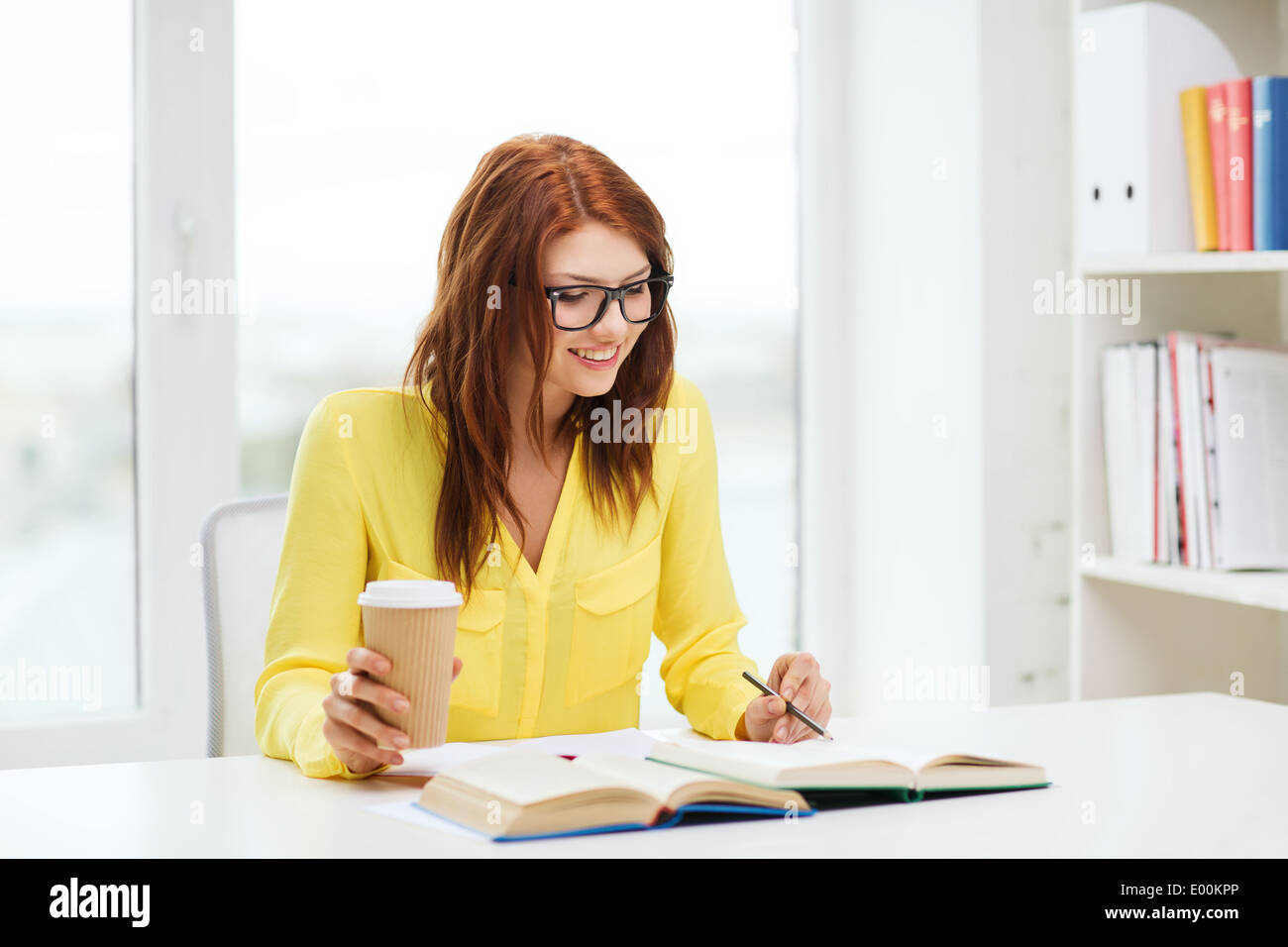 smiling student girl reading books in library Stock Photo - Alamy