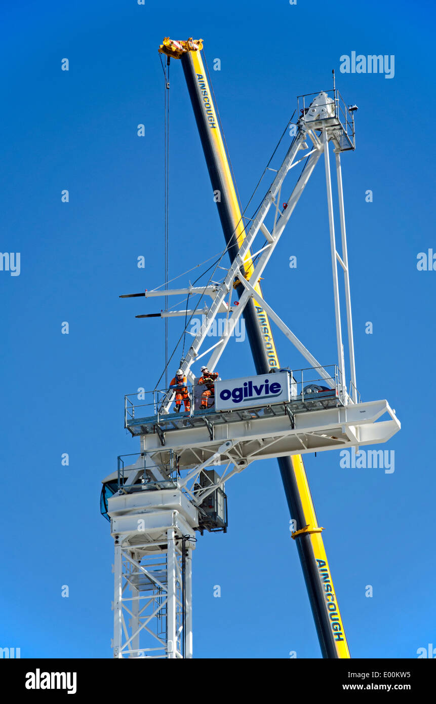 Two construction workers taking a break and admiring the view from a crane in Edinburgh. Stock Photo