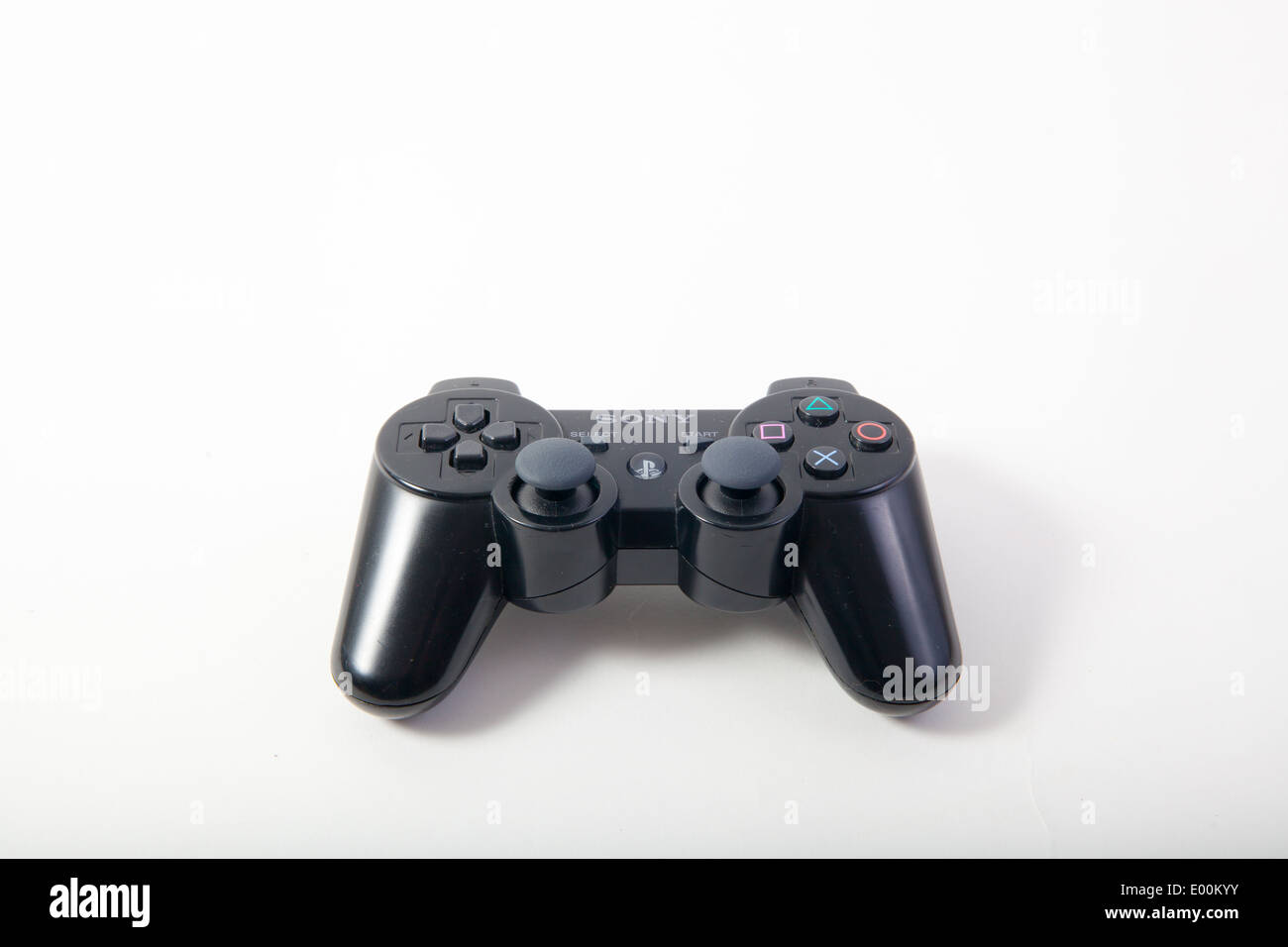Sony Playstation 3 and 4 original authentic black gaming controllers on a white studio background. Stock Photo