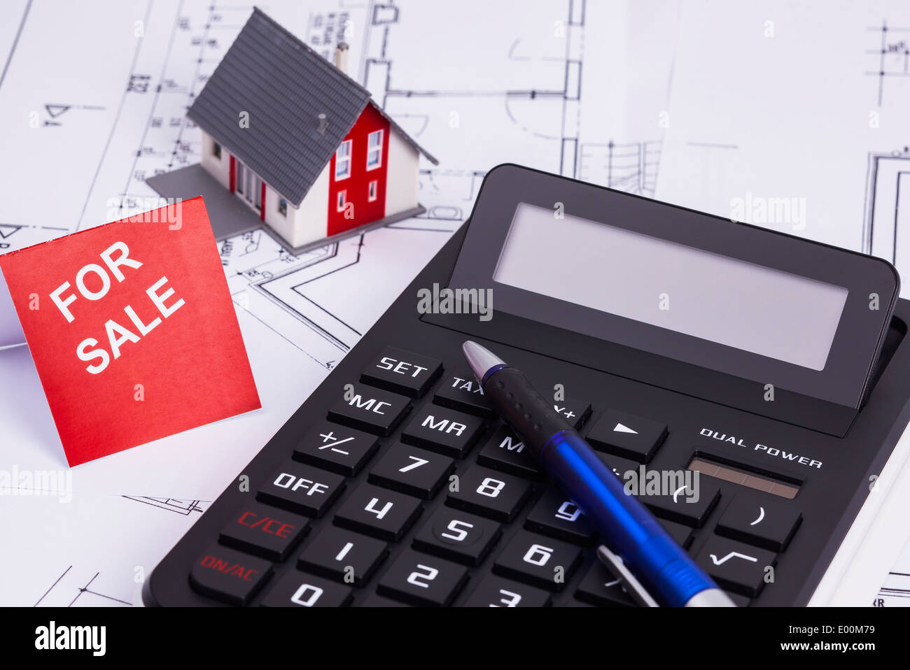 The image shows a calculator and a sold house Stock Photo