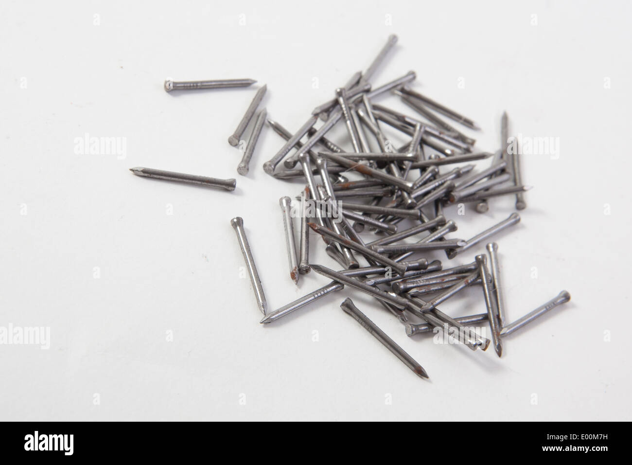 A close up of cross screws and nails on a white background. Stock Photo