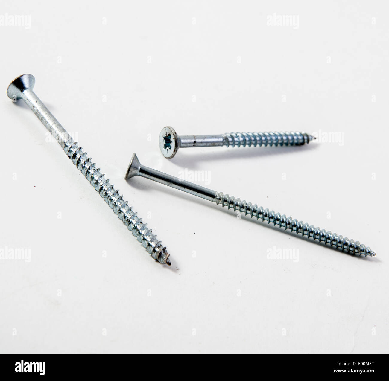 A close up of cross screws and nails on a white background. Stock Photo