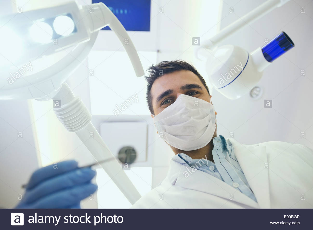 Dentist in surgical mask holding hi-res stock photography and images ...