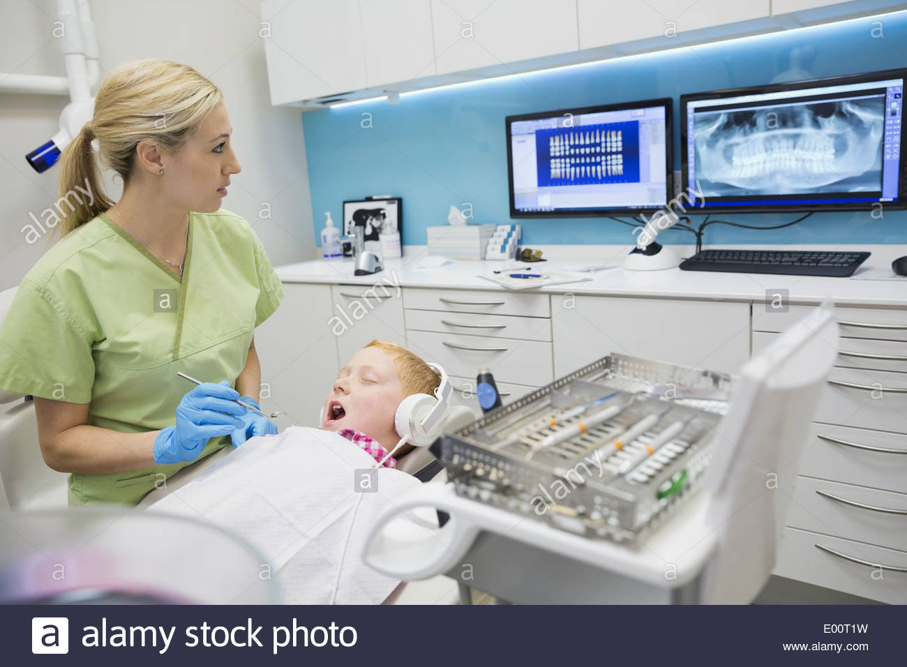 Dental assistant cleaning boys teeth Stock Photo Alamy
