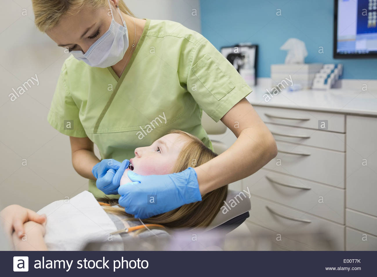 Dental assistant flossing girls teeth Stock Photo