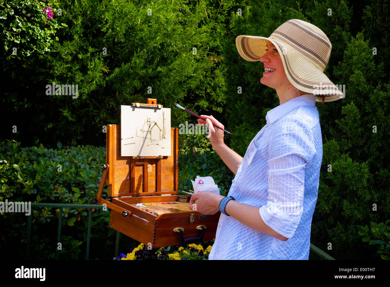 Smiling artist painting landscape 