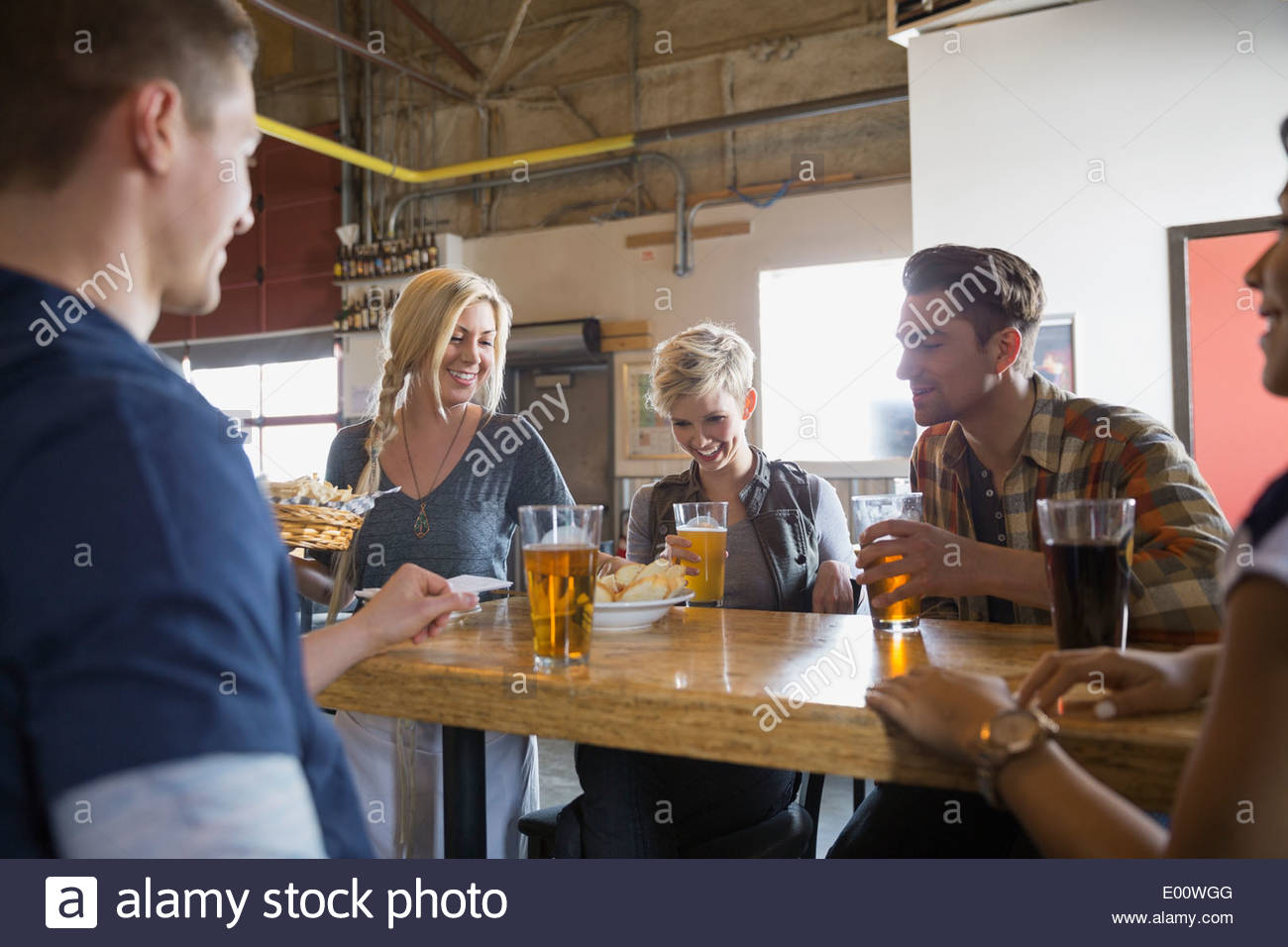 Brewery waitress serving food and beer to friends Stock Photo