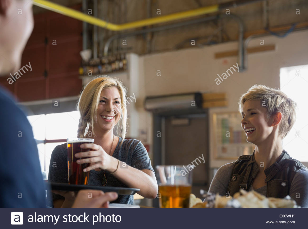 Waitress serving friends beer at brewery Stock Photo