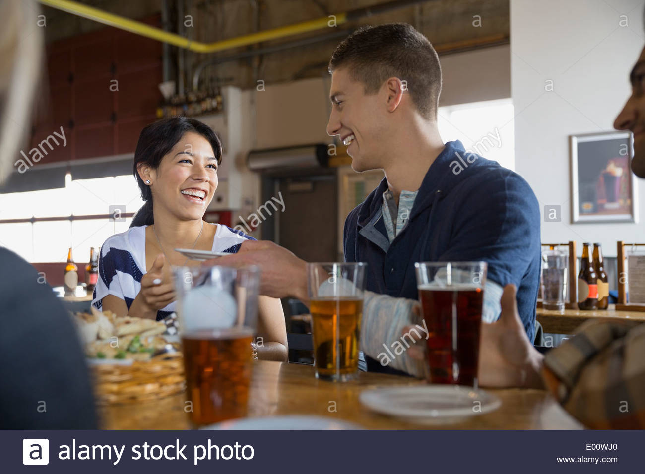 Friends eating and drinking beer at brewery Stock Photo Alamy