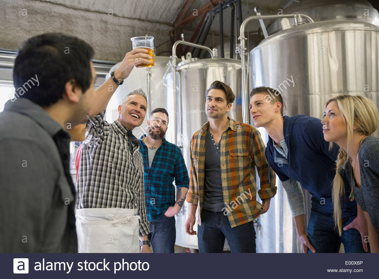 Brewery tour guide showing group beaker of beer Stock Photo Alamy