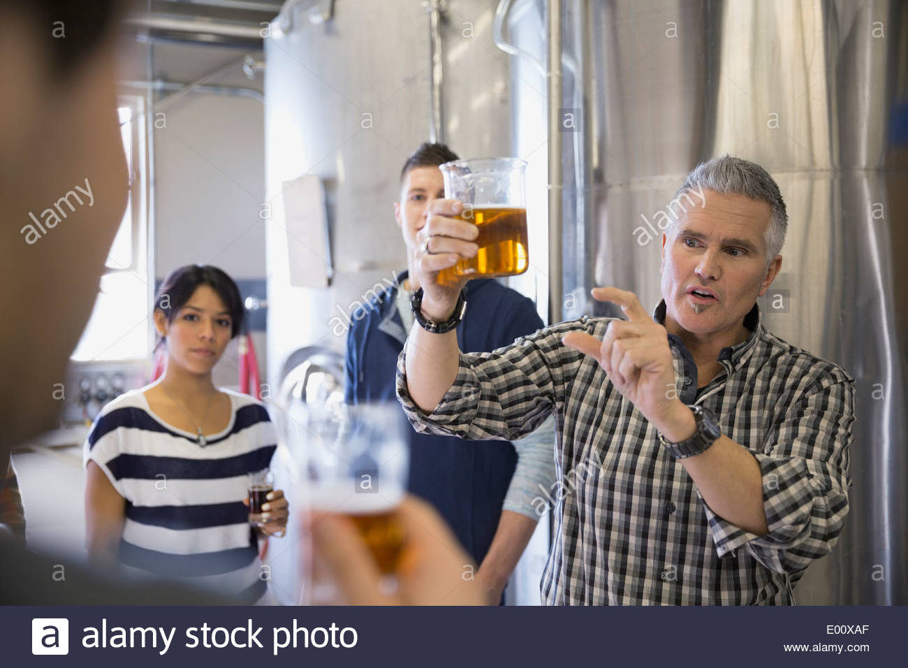 Brewery tour guide explaining beer in brewery Stock Photo Alamy