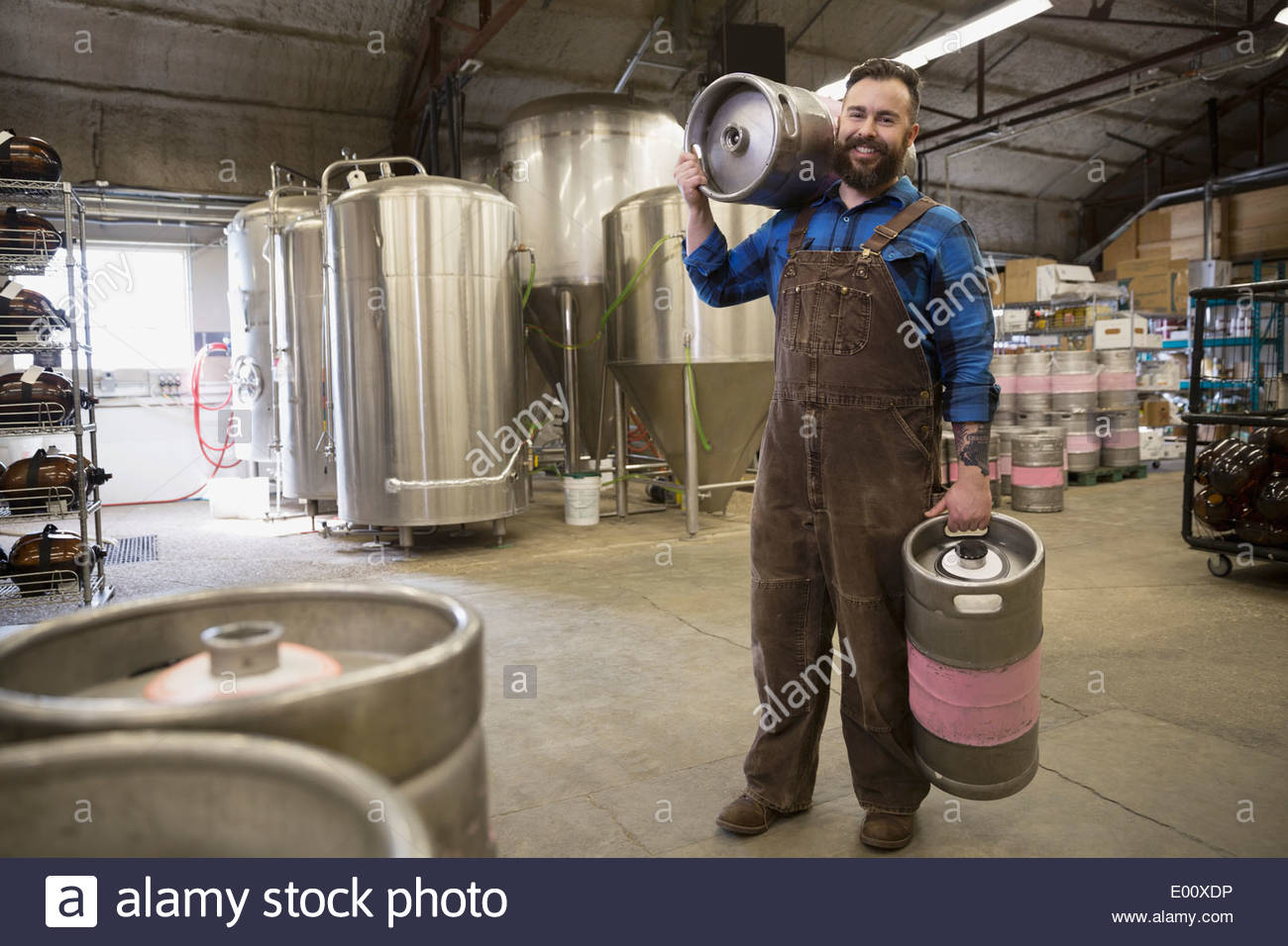 Portrait of brewery worker carrying quarter slim kegs Stock Photo Alamy