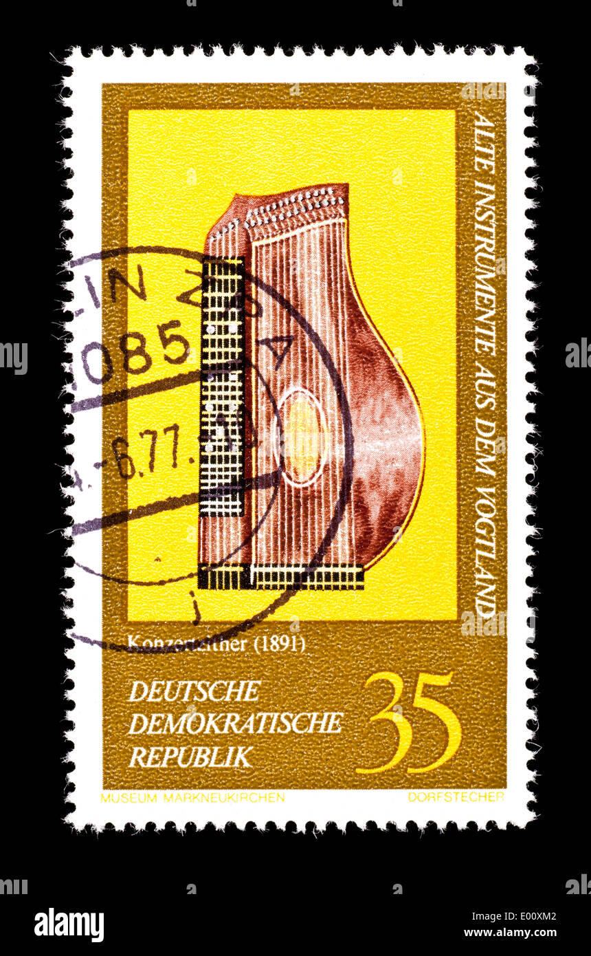 Postage stamp from East Germany depicting a Vogtland concert zither from 1891 from the Markneukirchen Museum. Stock Photo