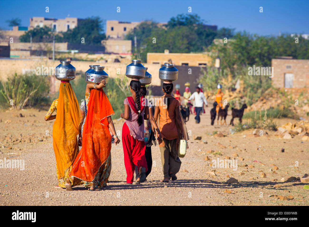 women lugging a water pot on their head Stock Photo