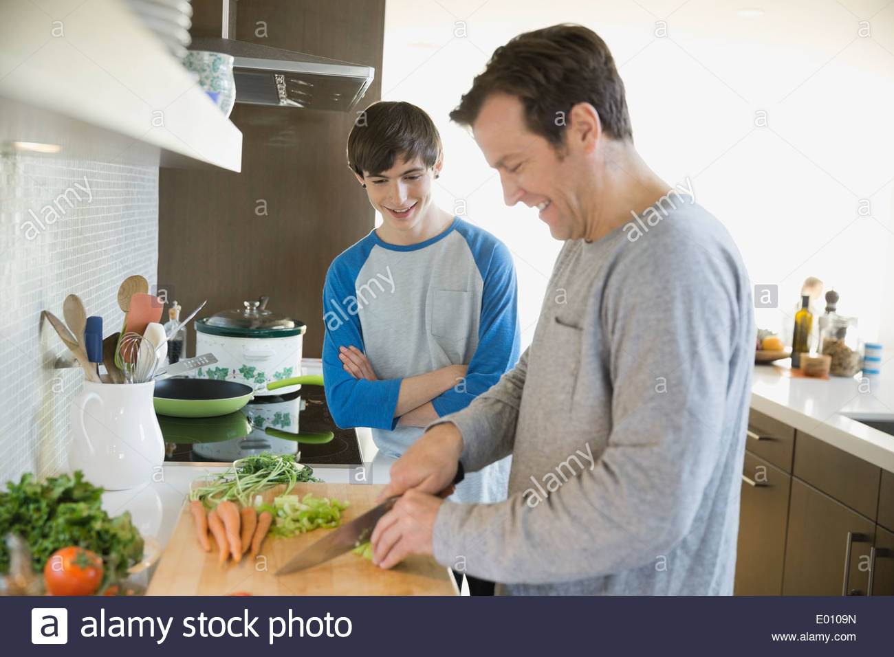 Father teaching son to cook in kitchen Stock Photo