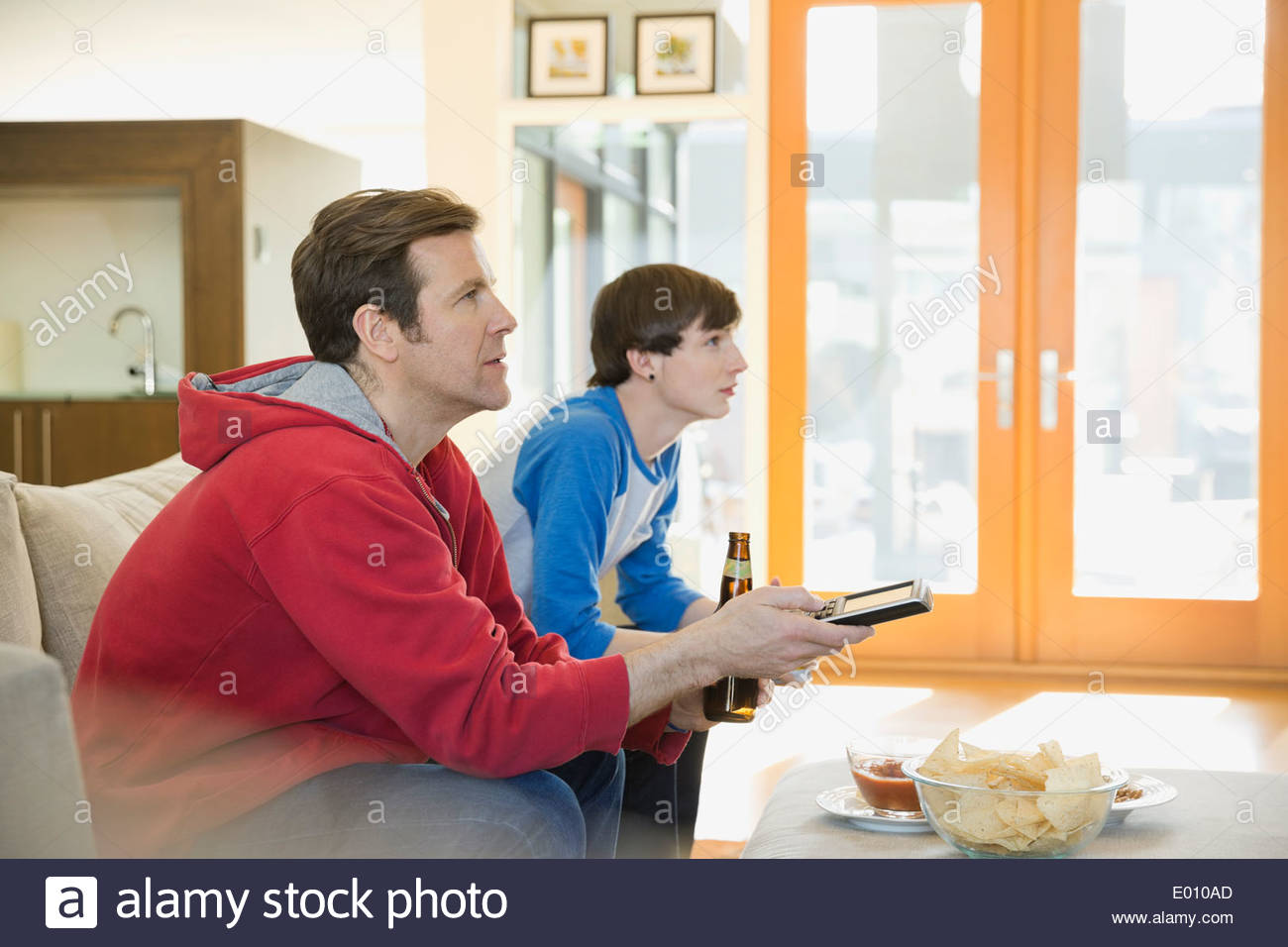Father and son watching TV in living room Stock Photo