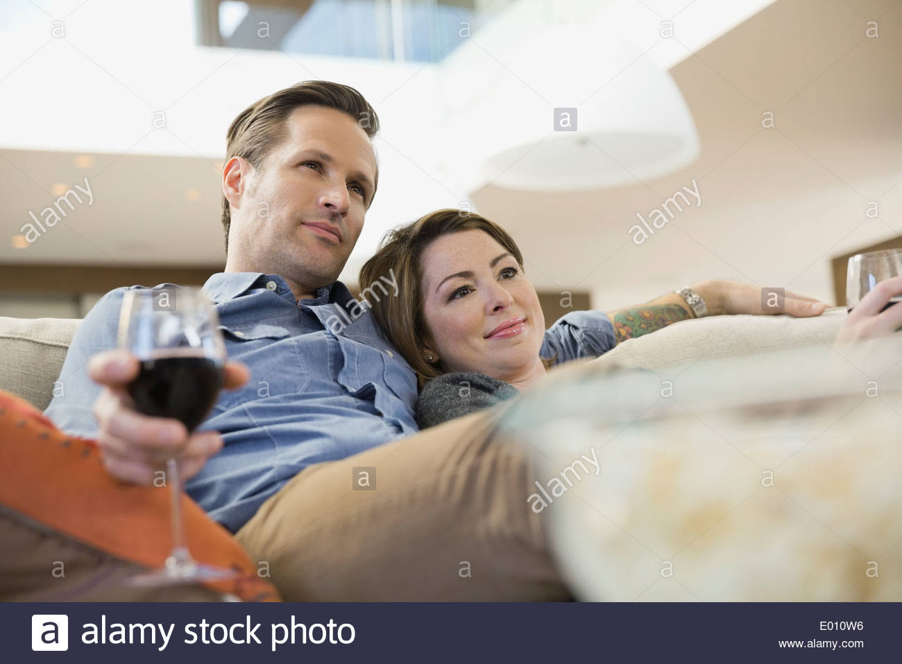 Couple with wine and popcorn watching TV Stock Photo