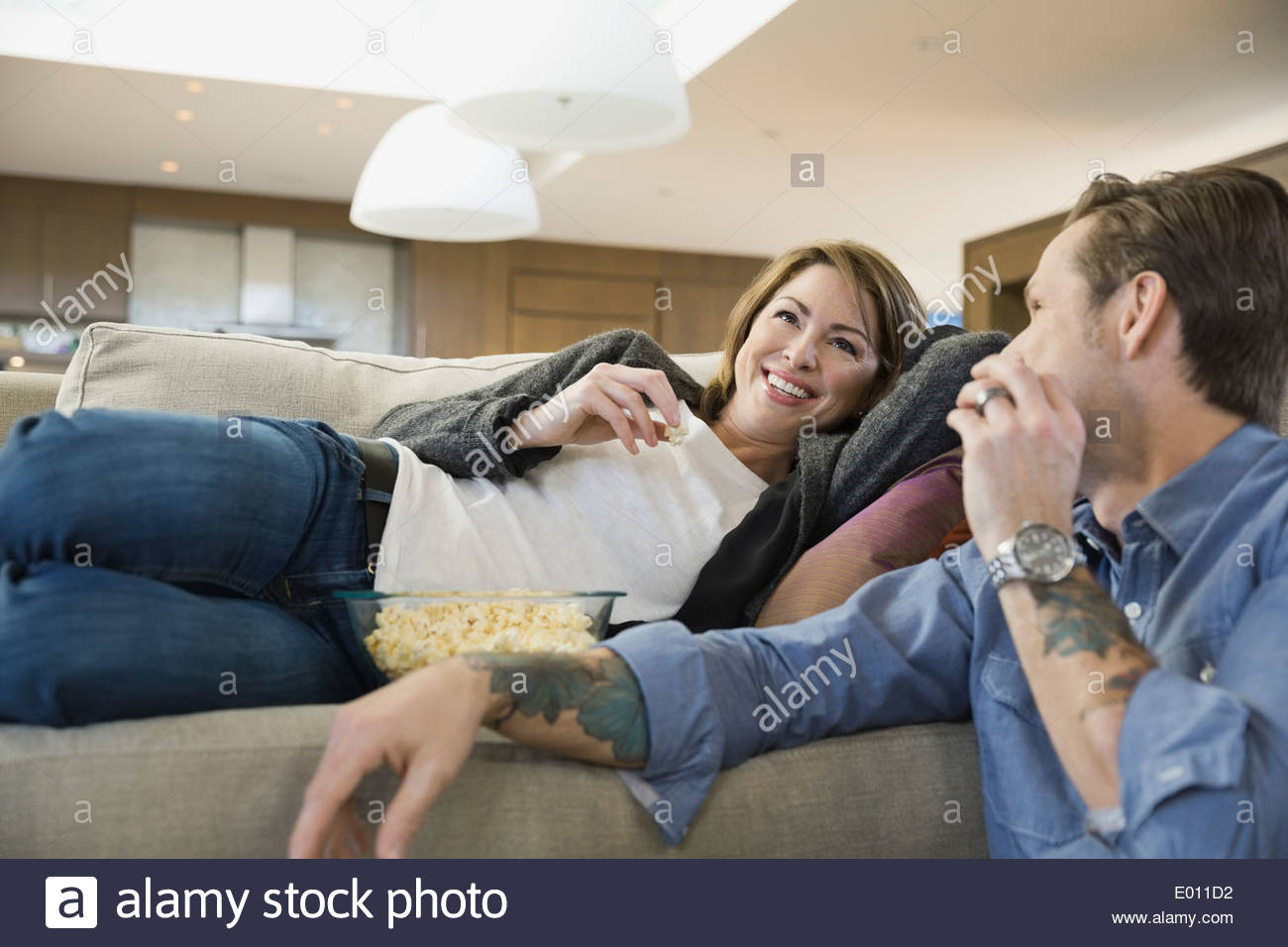 Couple eating popcorn and watching TV Stock Photo