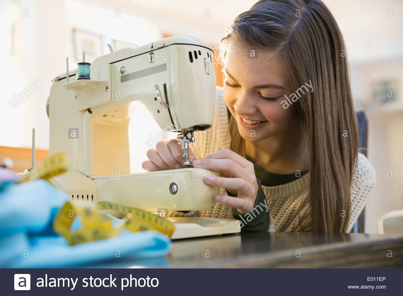 Girl using sewing machine Stock Photo