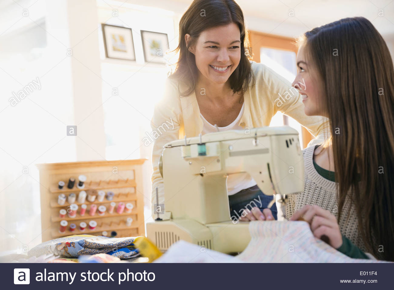 Mother teaching daughter how to use sewing machine Stock Photo Alamy