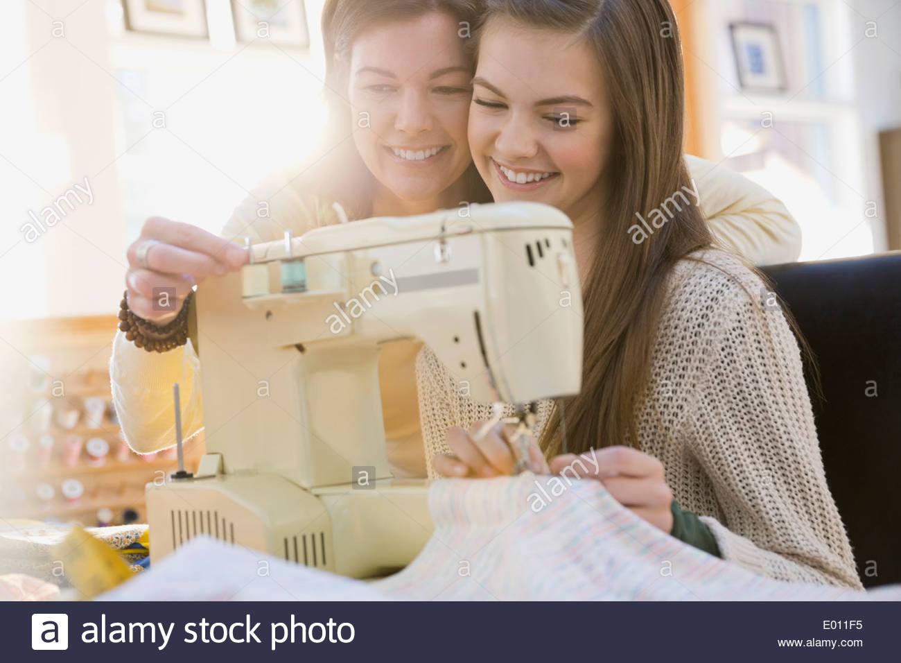 Mother teaching daughter how to use sewing machine Stock Photo Alamy