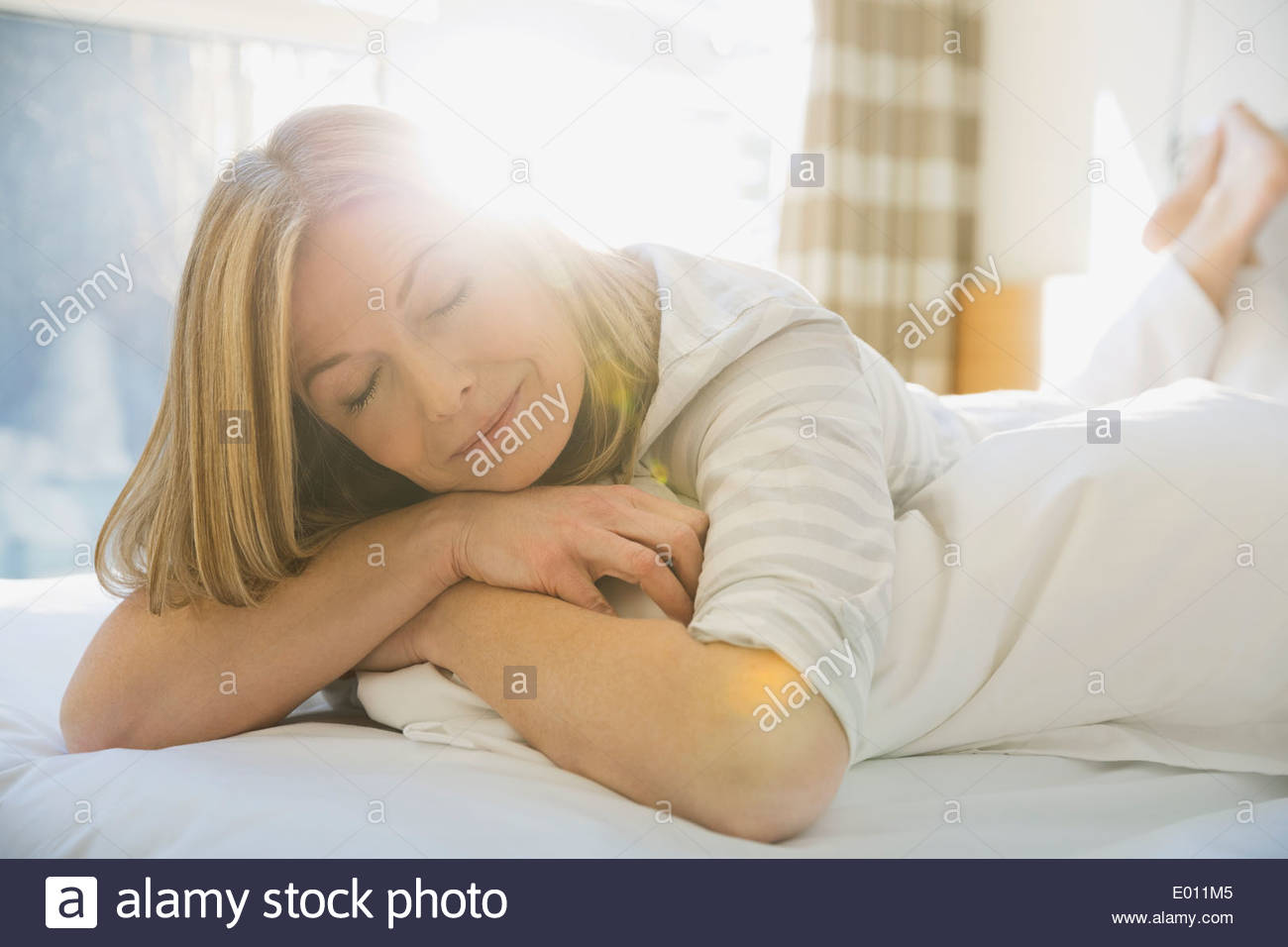 Woman napping on bed Stock Photo