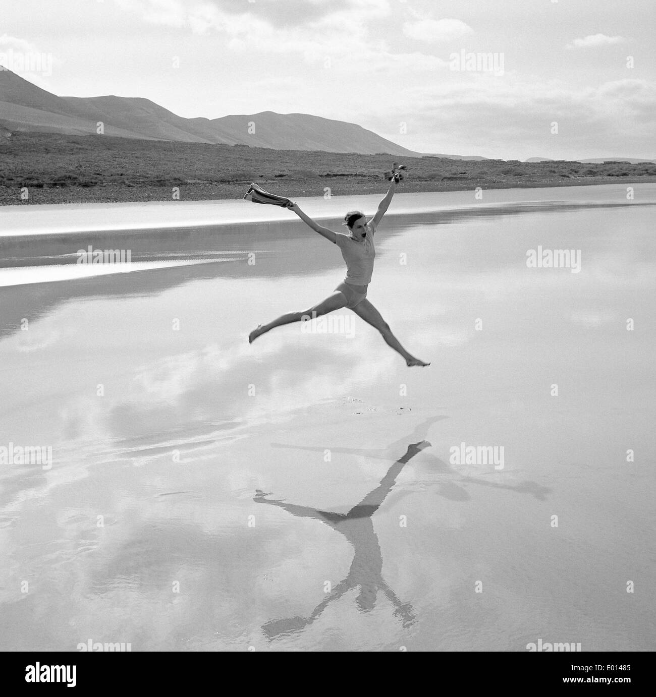 Woman jumping at the beach of Lanzarote, 1973 Stock Photo
