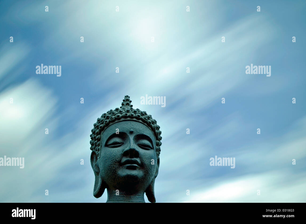 Buddha, photographed through an ND filter to give movement to the sky. Stock Photo