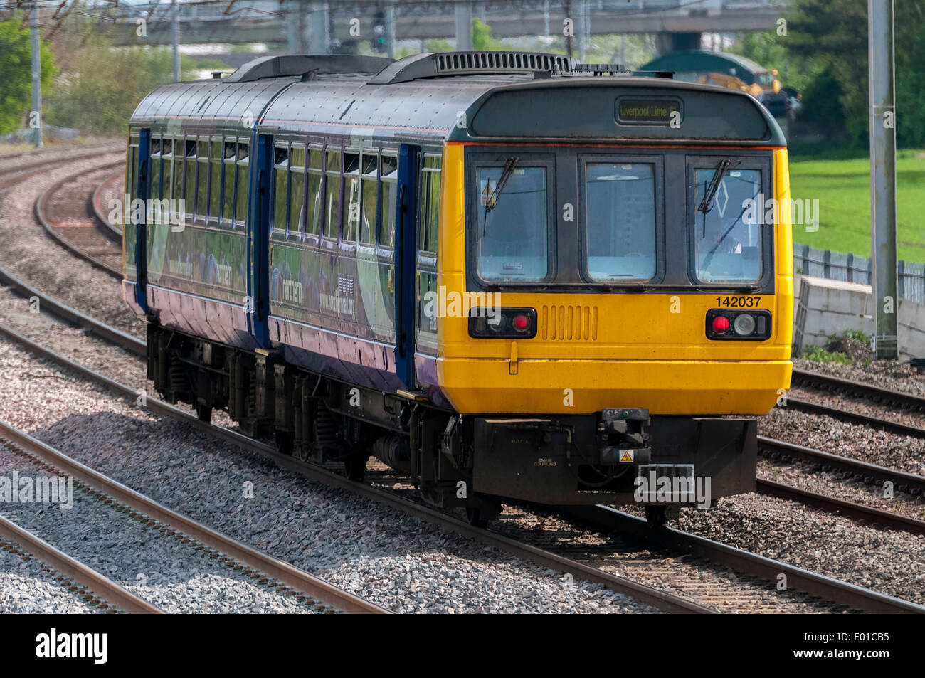 A Northern Rail British Rail Class 142 class Pacer diesel multiple  DMU on the West Coast main Line WCML at Winwick. Stock Photo