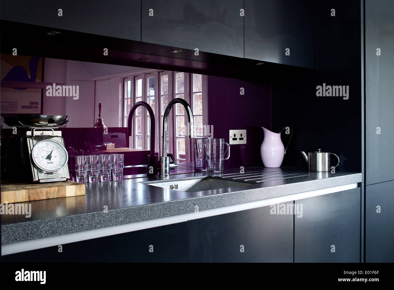 Kitchen detail, purple glass splashback behind the sink Stock Photo Alamy