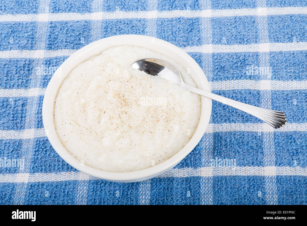 A bowl of fresh, hot grits with a spoon Stock Photo