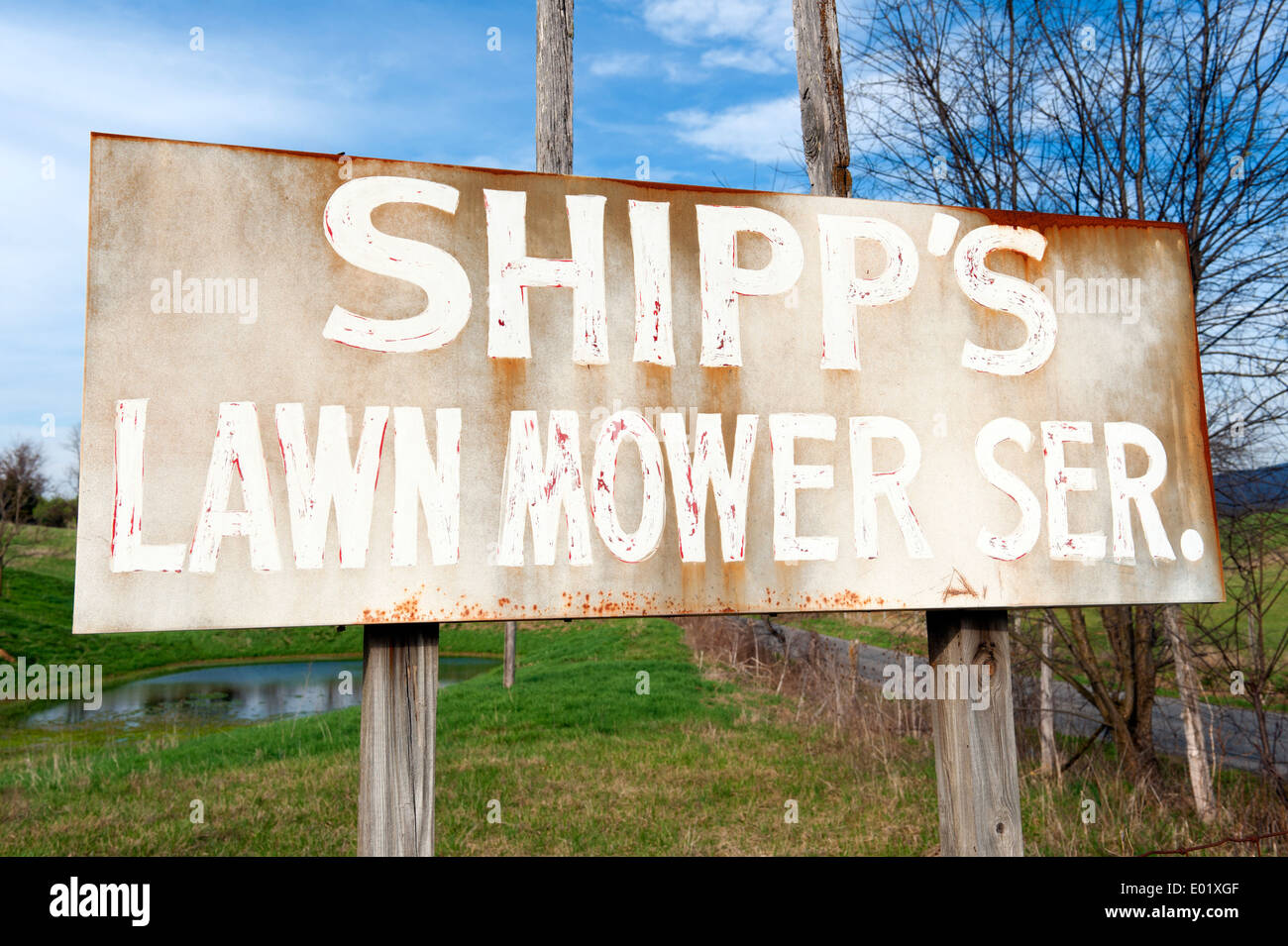 Old weathered sign for a lawn mower servicing business. Stock Photo