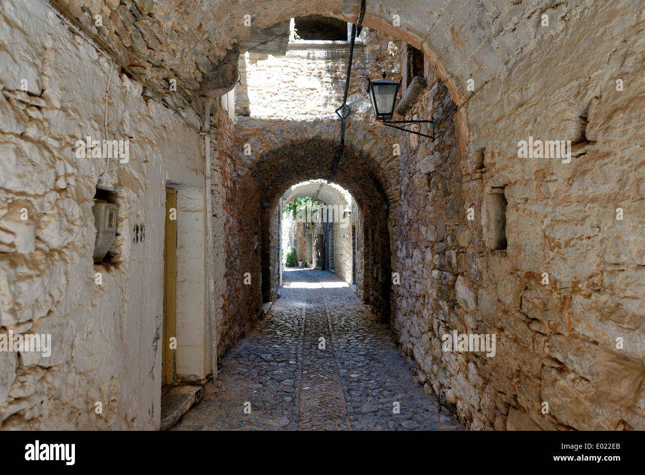 Vaulted arched narrow cobblestone lane lined with stone houses Medieval town Mesta Chios Greece pentagon shape and Stock Photo