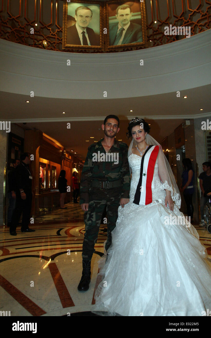 Damascus, Syria. 29th Apr, 2014. A Syrian couple take part in a mass  wedding held at the Dama Rose hotel in Damascus, Syria, April 29, 2014.  Twenty bridegrooms wearing their military uniforms