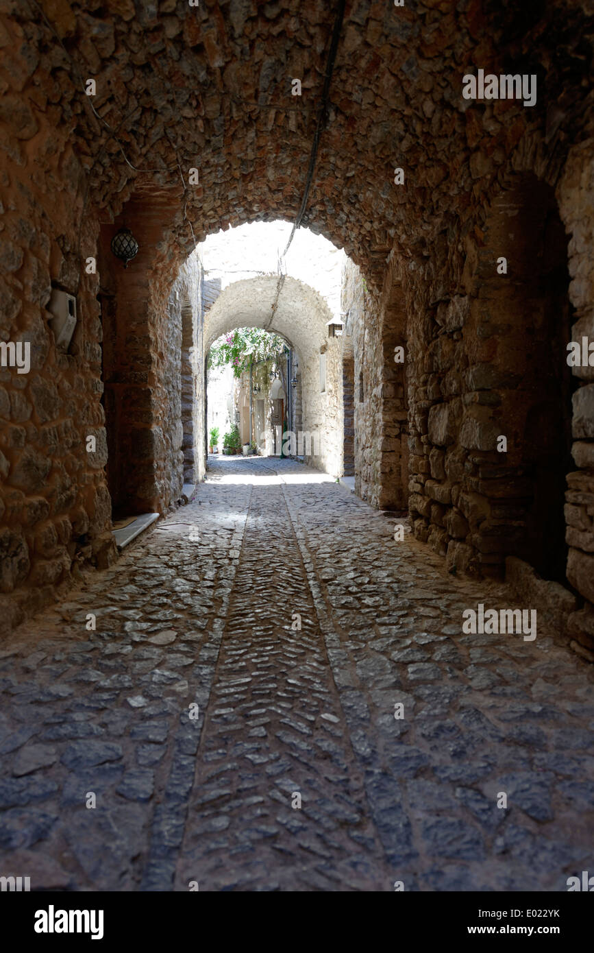 Vaulted arched narrow cobblestone lane lined with stone houses Medieval town Mesta Chios Greece pentagon shape and Stock Photo