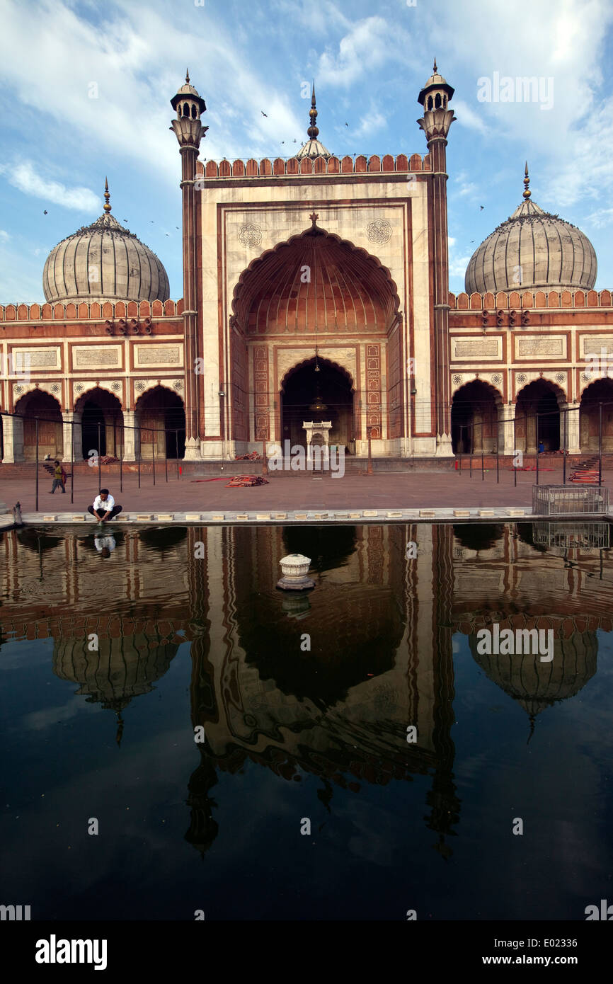 A man ritually washes in a pool that reflects the The Jama Masjid (The Friday Mosque), Old Delhi, India Stock Photo