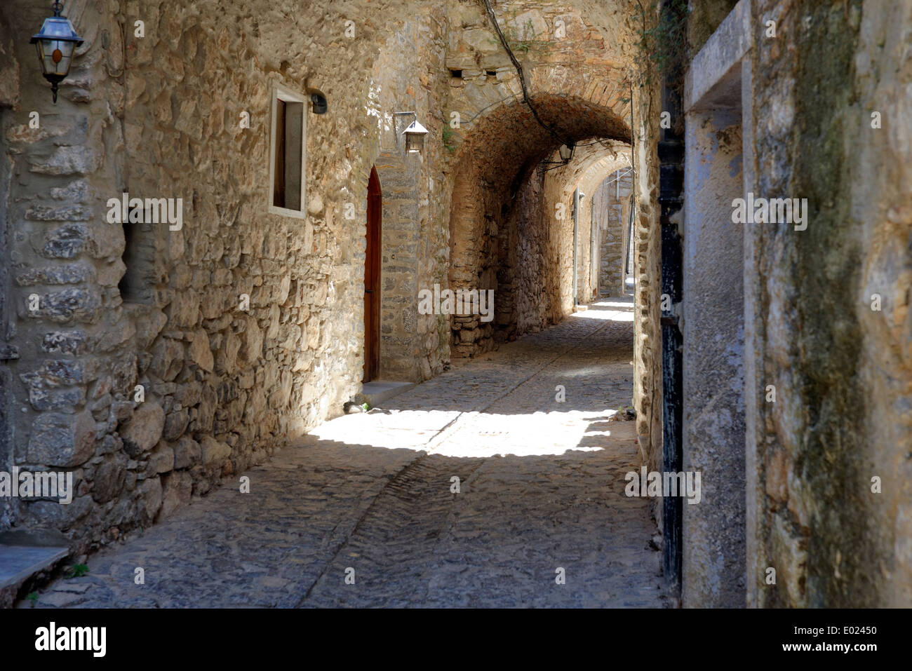 Vaulted arched narrow cobblestone lane lined with stone houses Medieval town Mesta Chios Greece pentagon shape and Stock Photo